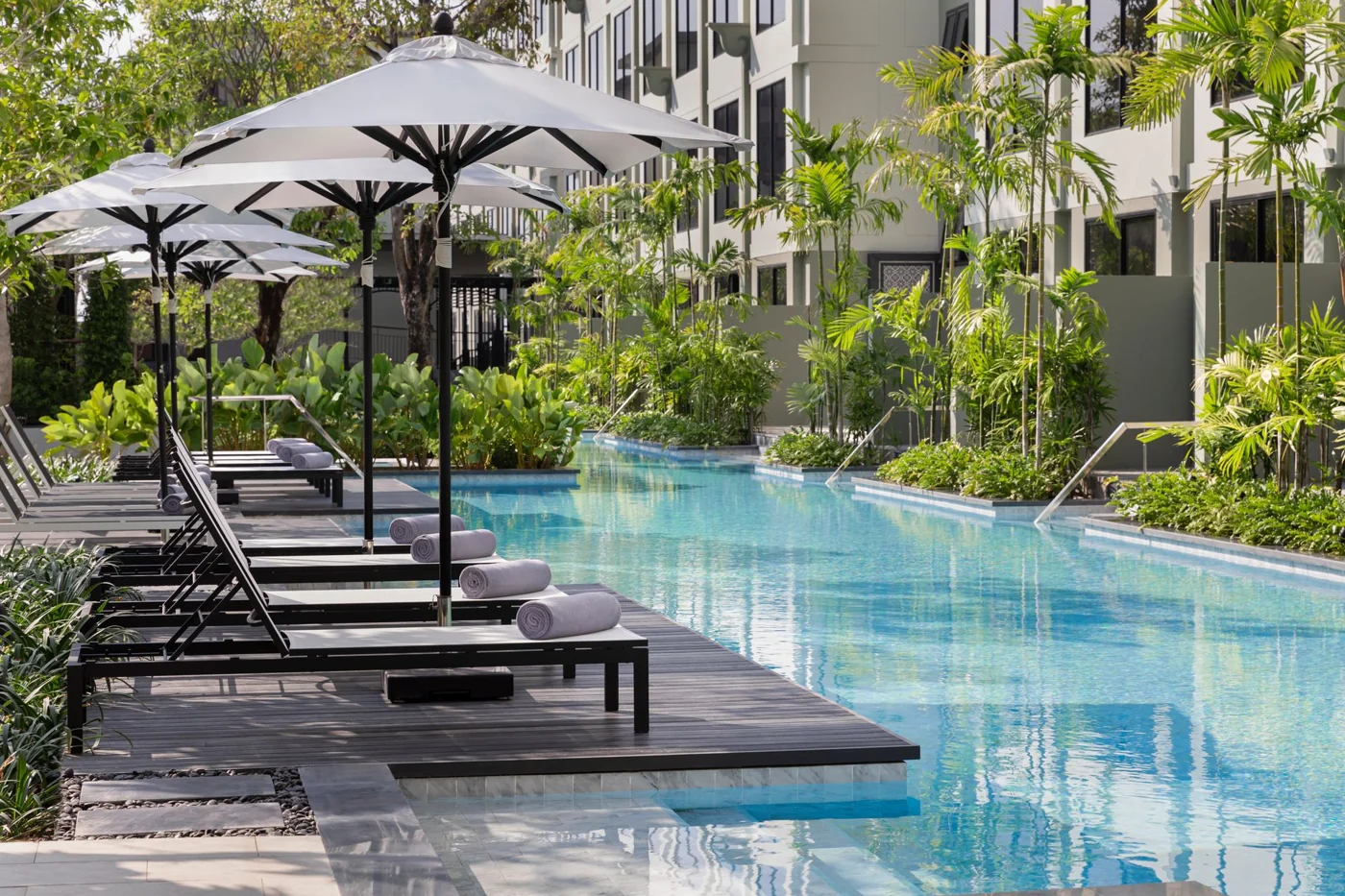 A hotel pool with sun loungers and umbrellas
